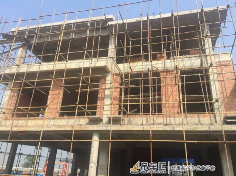 吊车吊着挖掘机来挖地基 这房子成本有点高吧