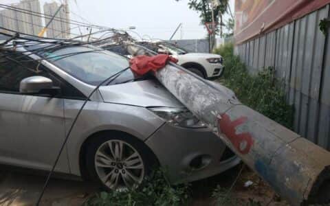 一吊车郑州街头“横扫千军”，挂倒2根电线杆砸坏8辆车！现场狼藉