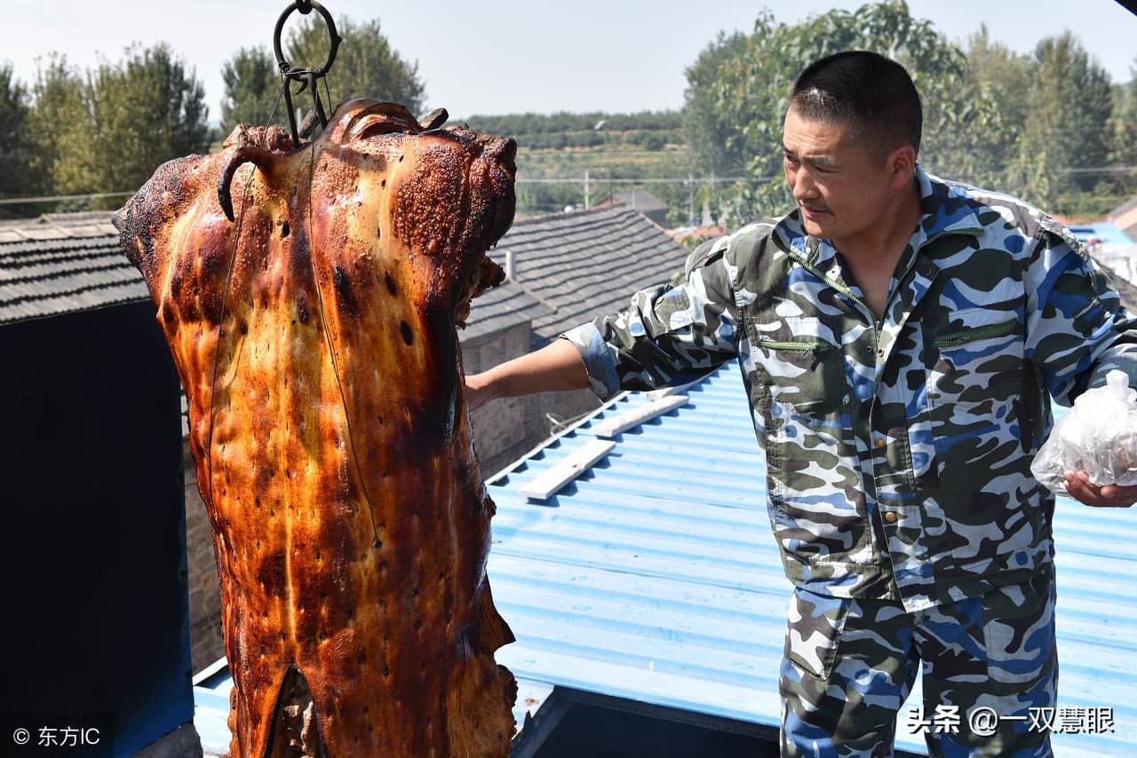 夫妻俩用起重机做脆皮烤猪,经验不足,一头猪掉到炉底,全烤糊了
