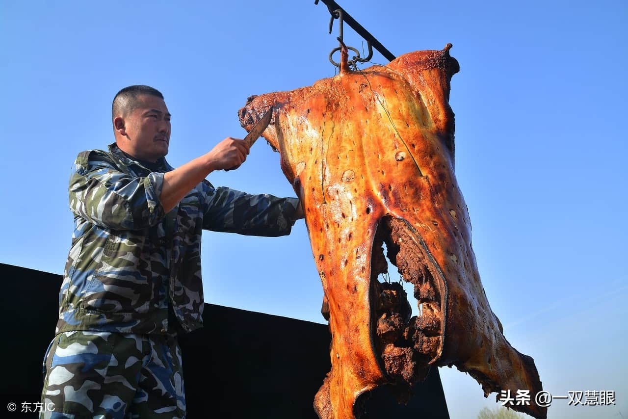 夫妻俩用起重机做脆皮烤猪,经验不足,一头猪掉到炉底,全烤糊了