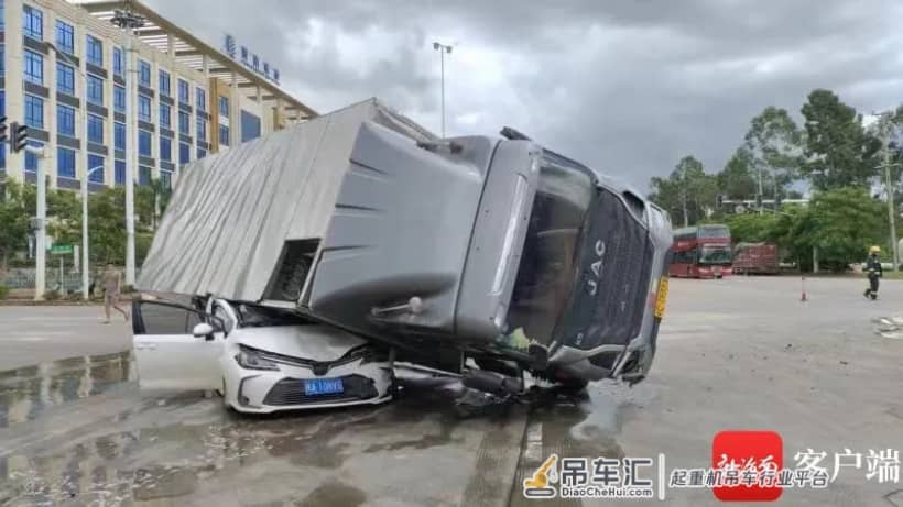 海南澄迈一辆大货车倾斜压瘪轿车,幸有路过吊车协助救援