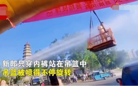 新郎被吊车吊起用高压水喷 网友称应该禁止低俗的婚闹